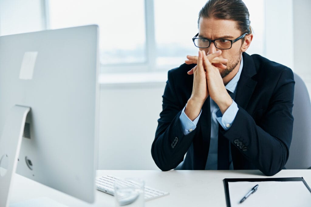 Male executive at his desk looking confused